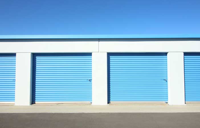 Large drive-up storage units with roll-up doors.